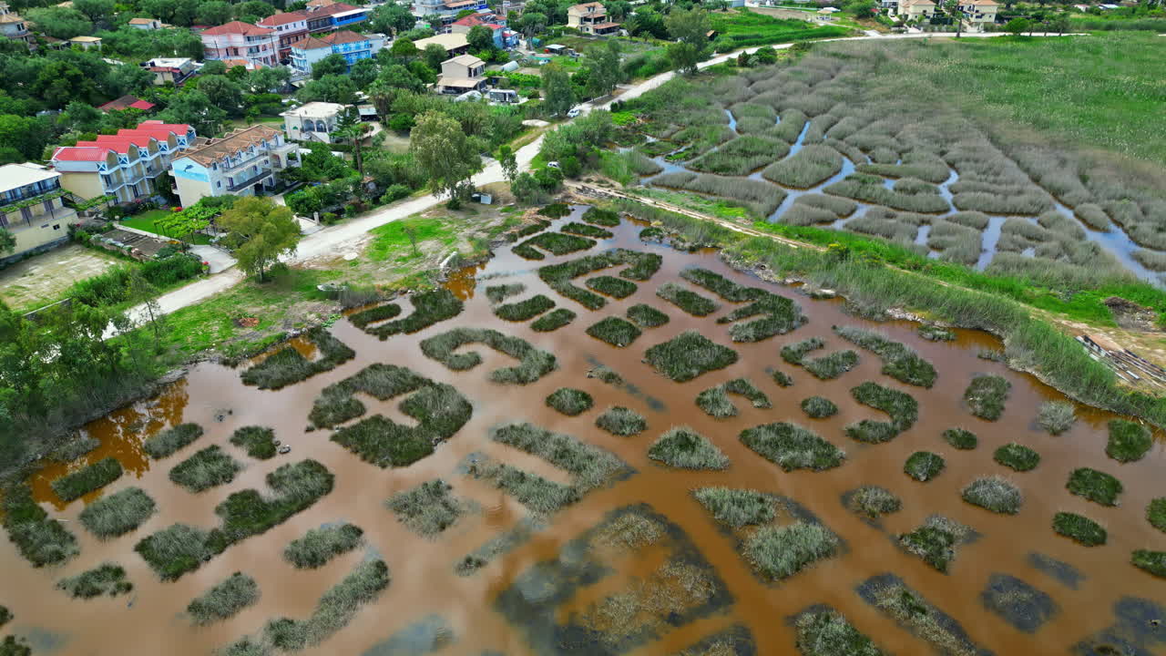 Flooded agriculture fields near small township of Latvia, aerial view