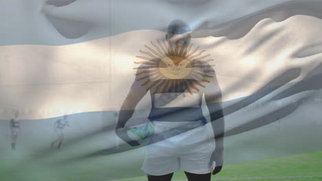 animation of argentina flag and african american male player with rugby ball standing on ground