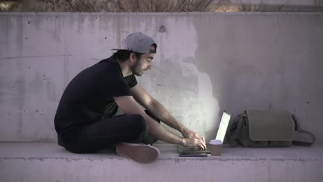 man working on laptop outdoors at night