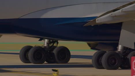 close-up of airplane landing gear on airport tarmac