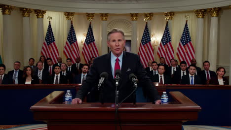 politician delivers a speech at a podium with american flags