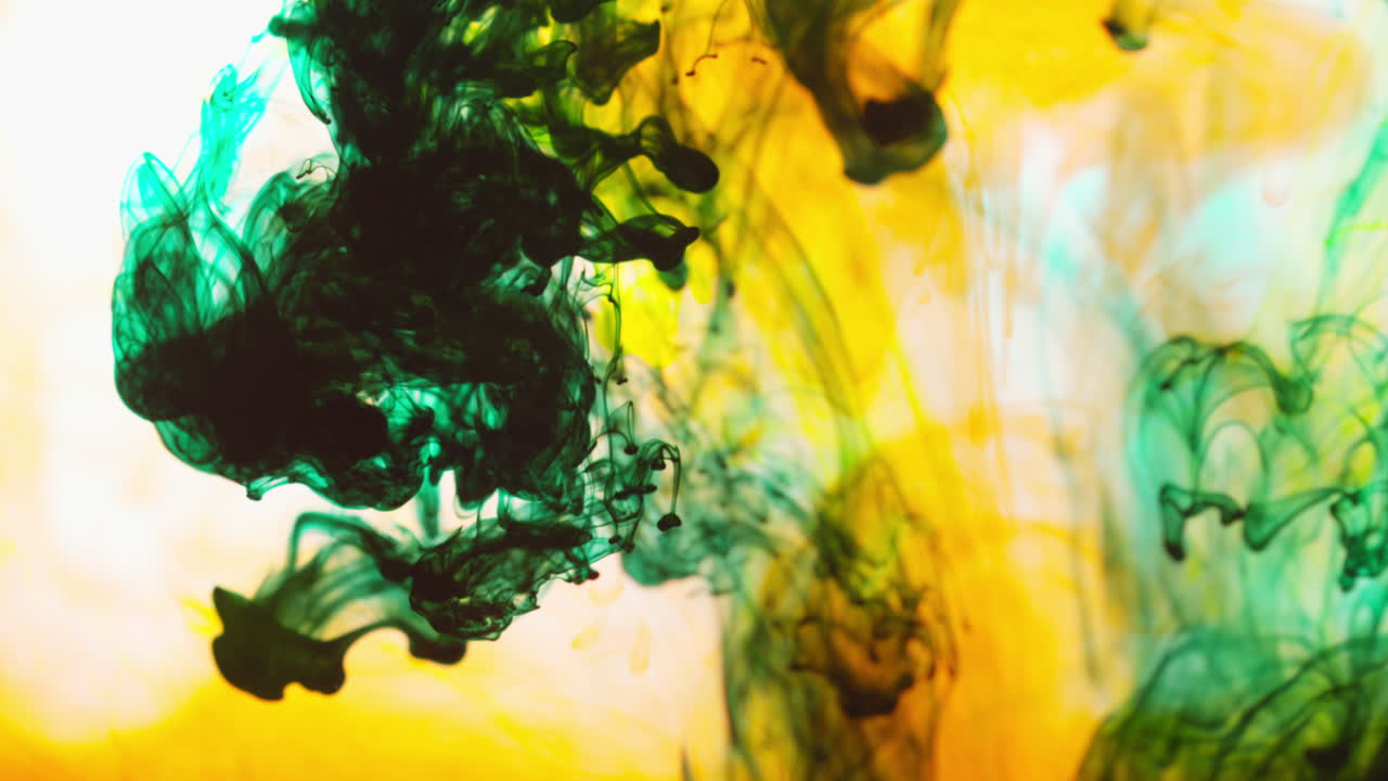 pintura o tinte verde y naranja caído en el agua contra un fondo blanco para crear un fondo de humo de colores giratorios 5