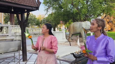 women praying at a thai temple