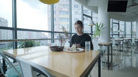 girl eating salad in cafe