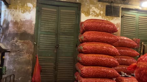 inside storehouse with stacked onion sacks. pan right