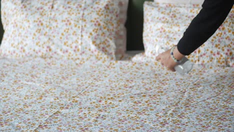 a woman spraying her bed sheets with a spray bottle