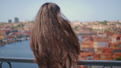 brunette woman turning camera river bridge back view. lady contemplating water
