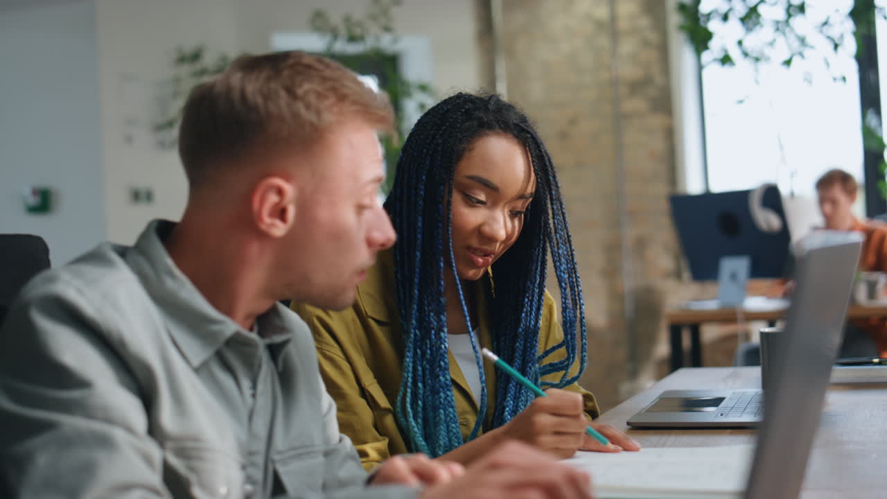 Couple coworkers consulting together sitting coworking close up. Office workers