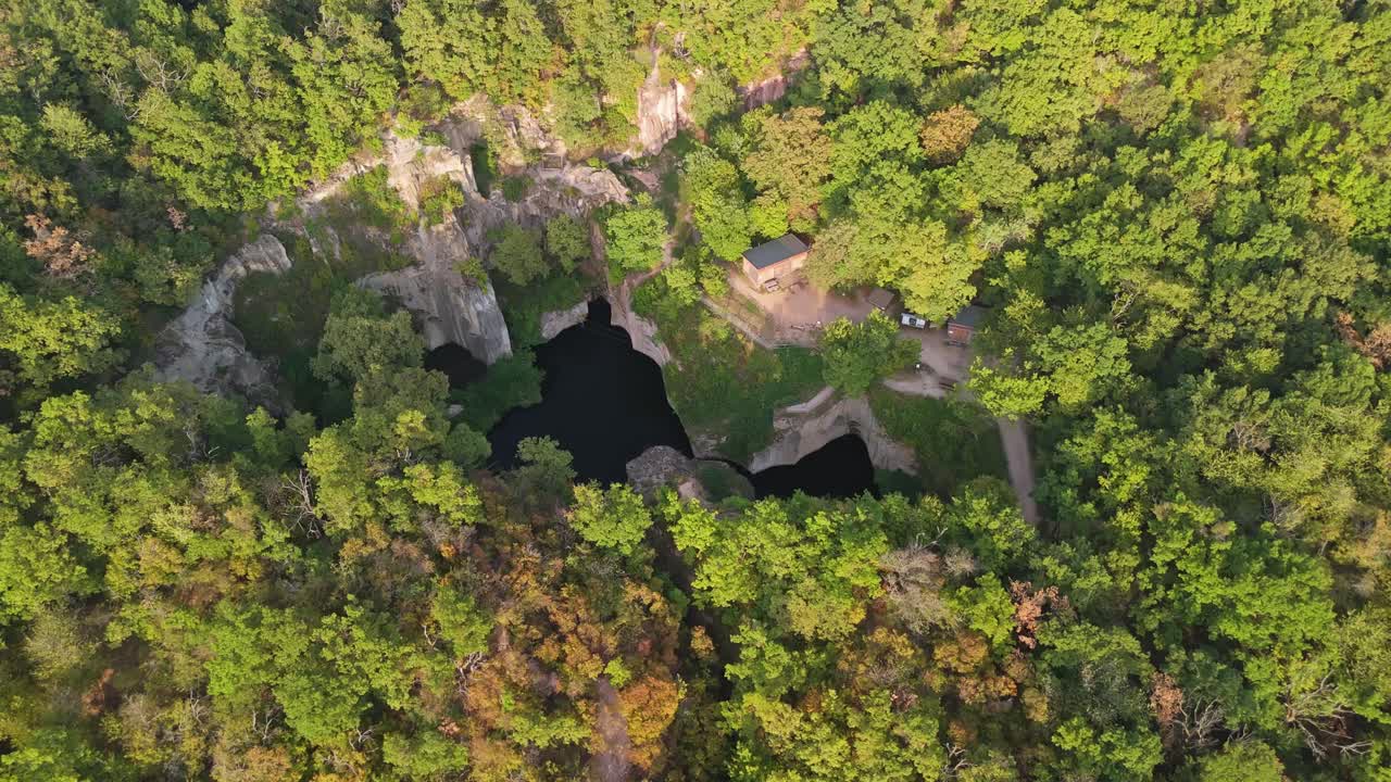 Zdjęcie lotnicze jeziora Tarn of Megyer-hegy w pobliżu Sárospatak na Węgrzech, ukazujące bujną zieleń, spokojne wody i historyczne formacje kamieniołomu w malowniczym rezerwacie przyrody