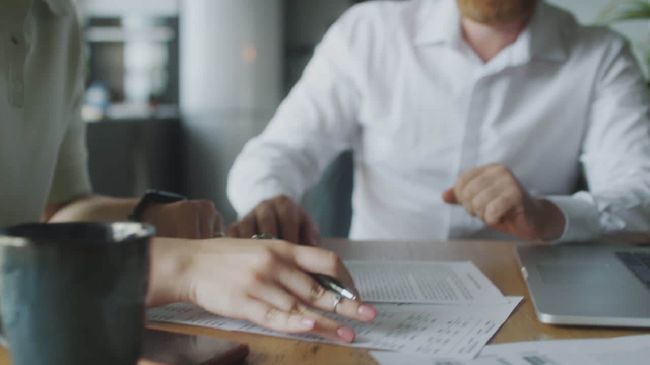 Woman Signing Contract with Financial Planner