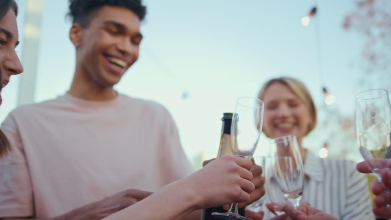 las manos del tipo abriendo una botella de vino en el parque de cerca.