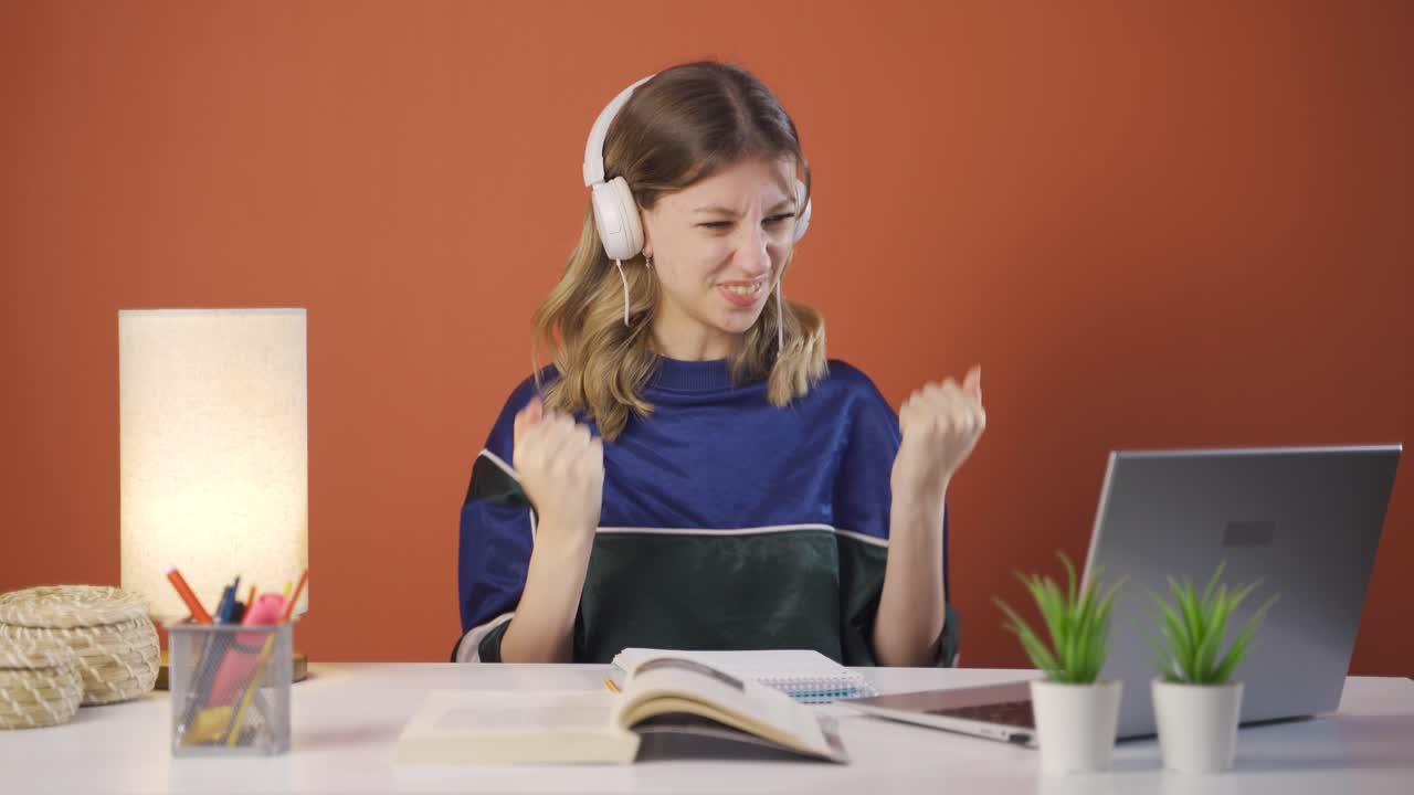 mujer joven mirando la computadora portátil aplaudiendo.