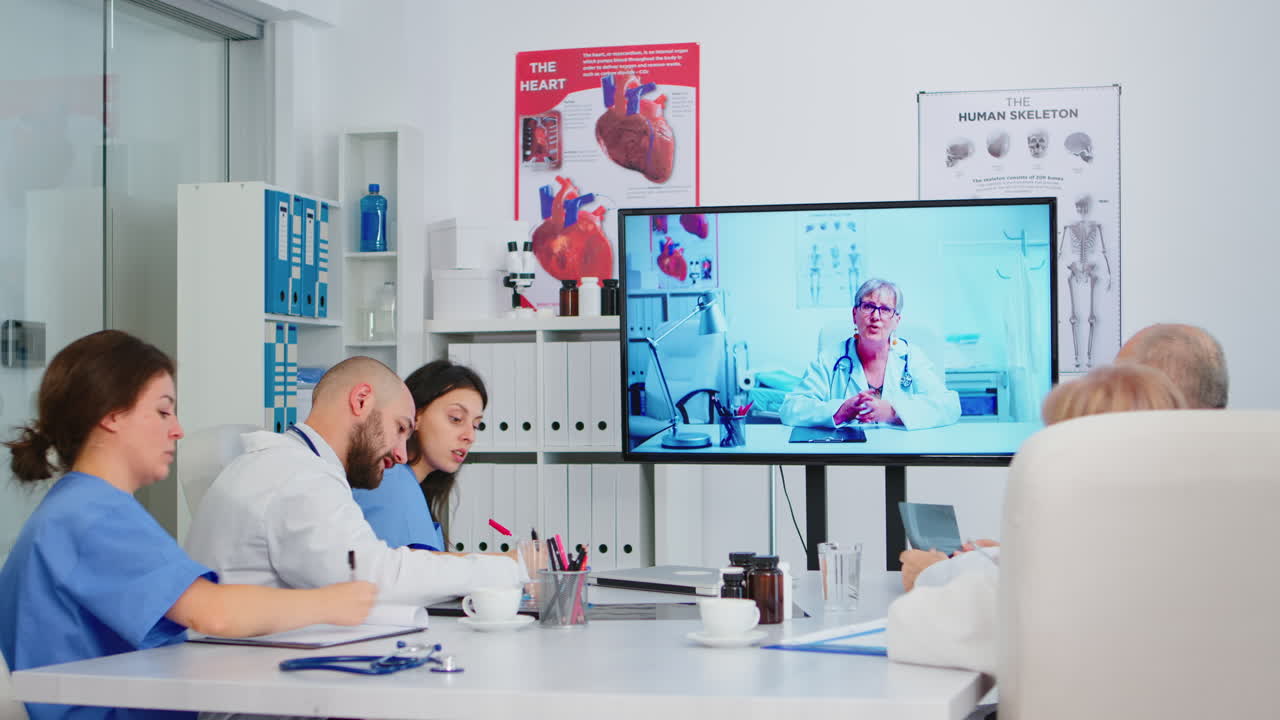 전문적인 팀워커들이 교육용 의료 비디오를 보고 있습니다.