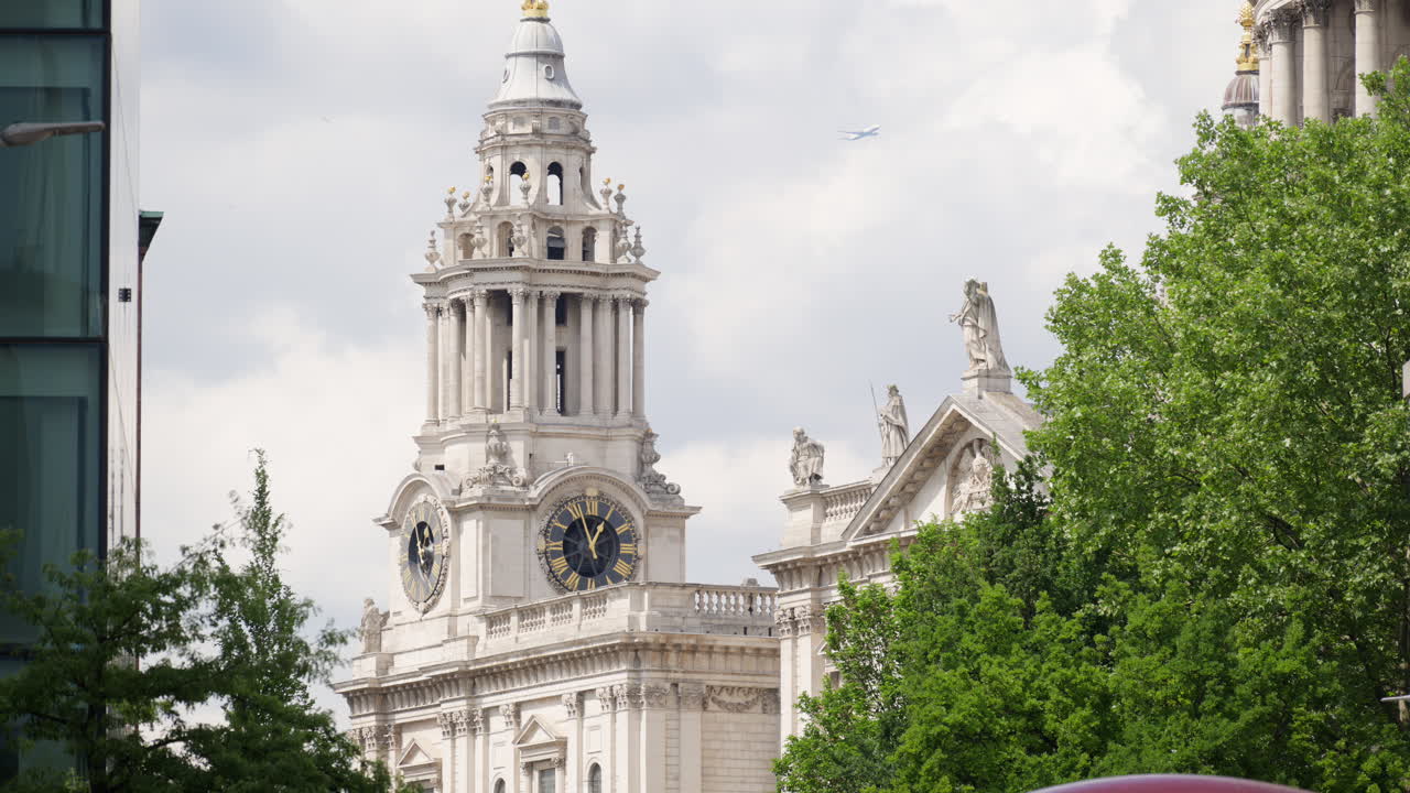 Close up of St. Paul's Cathedral's clock tower partially hidden by trees in London, England in daylight