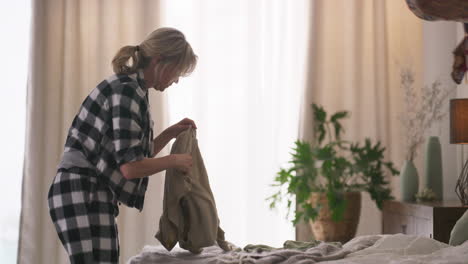 woman sorting clothes in bedroom