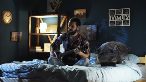 couple singing and playing guitar in bedroom