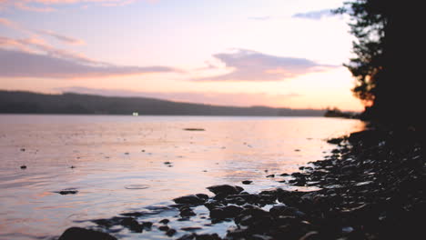 Close-up-at-ground-level-of-rain-on-the-lake-at-sunset