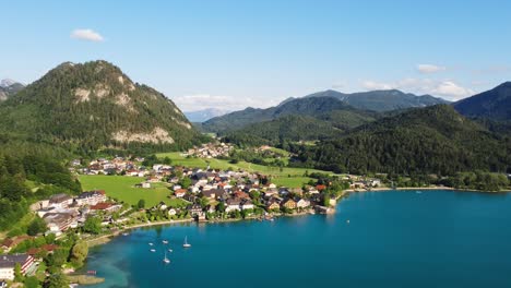 4k aerial drone view of austrian village town of fuschl facing lake in summer