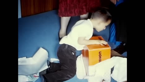 little boy sitting on floor with tie on. circa usa - 1970s: a young boy in the 1970s sits on the floor wearing a tie.