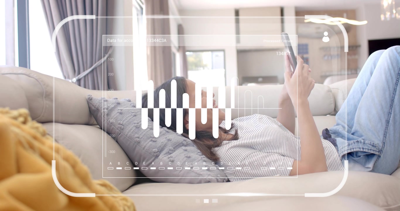 woman reclining on sofa and tapping tablet to adjust transparent UI waveform overlay for analysis