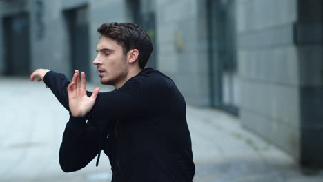 Handsome-man-stretching-arms-on-workout-outdoor.-Male-athlete-warming-up