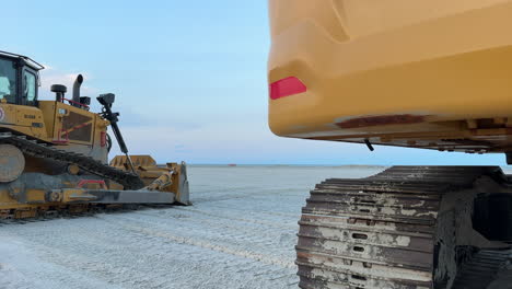 bulldozers working on a beach