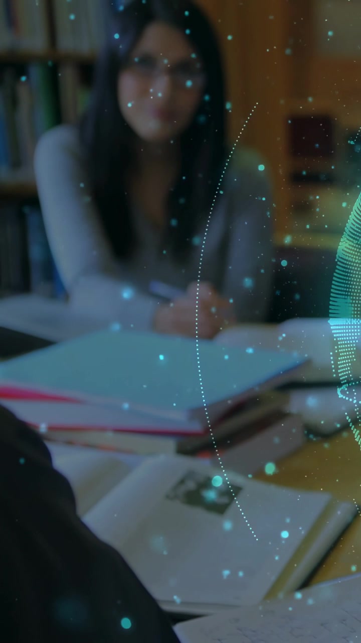 Vertical video: Woman sitting at table with books HUD globe sweeping right drawing focus to study