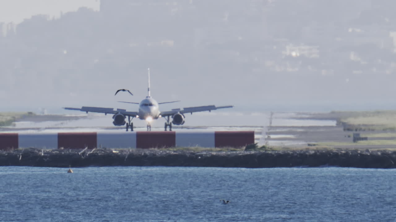Distant view of airplanes landing at the Nice Cote d'Azur Airport in daylight