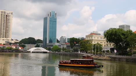 barco turístico navegando a lo largo de un río de la ciudad.