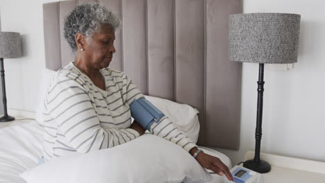 Senior-african-american-woman-checking-blood-pressure,-slow-motion