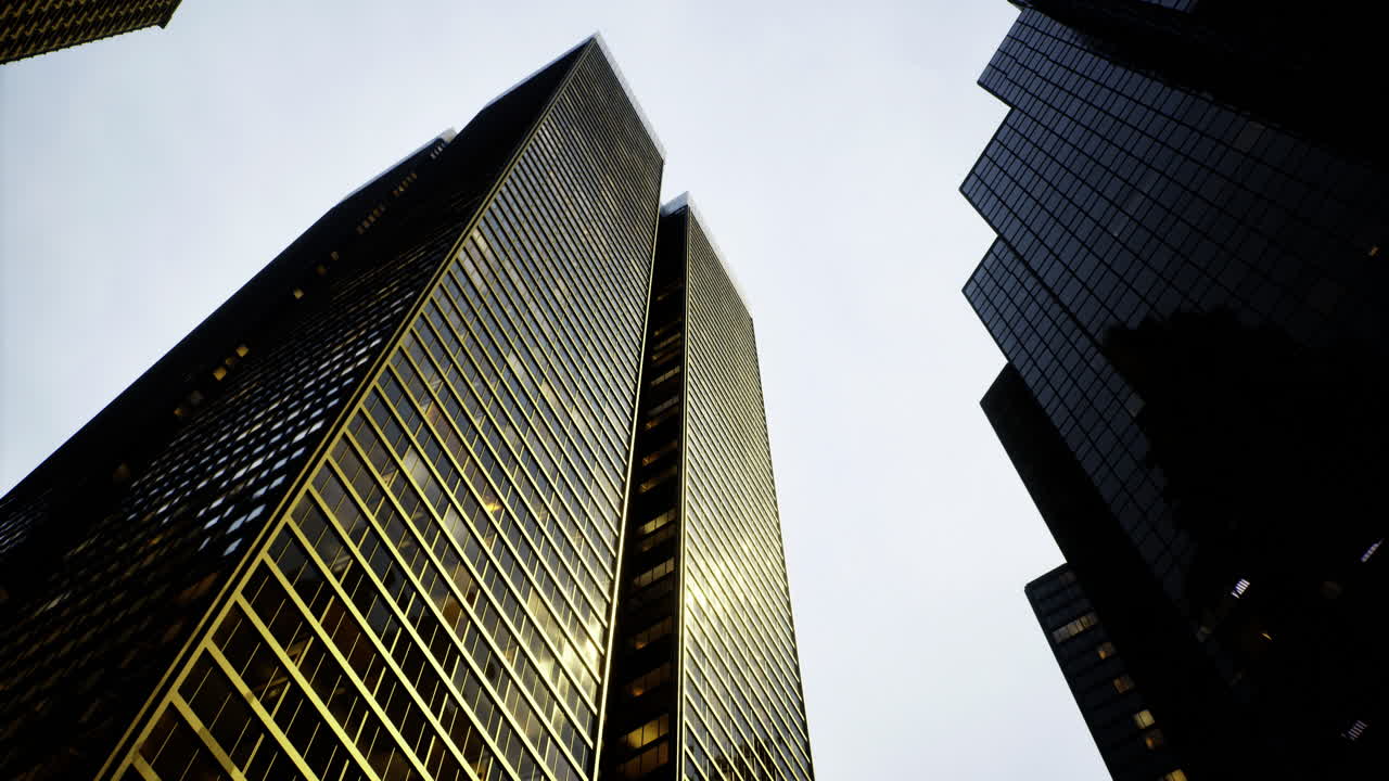 Skyscrapers reflect light in a bustling urban setting on a cloudy day