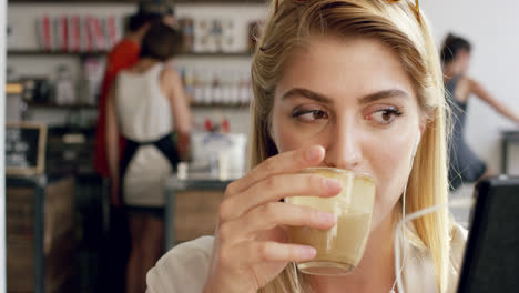 Hermosa-Mujer-De-Mensajería-De-Vídeo-Con-Pantalla-Táctil-Tablet-pc-En-La-Cafetería.