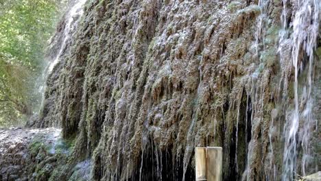 pared de roca cubierta en el flujo de agua