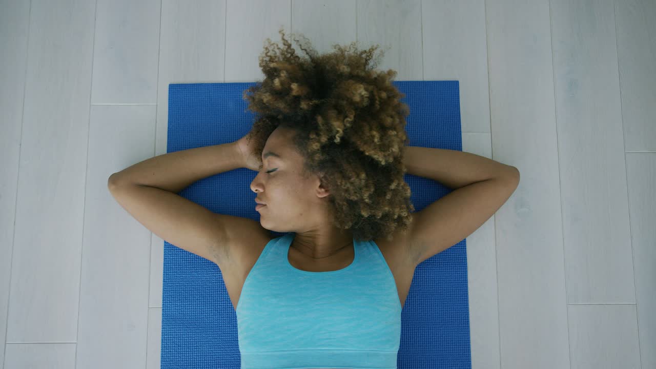 Mulher no tapete relaxando após o treino