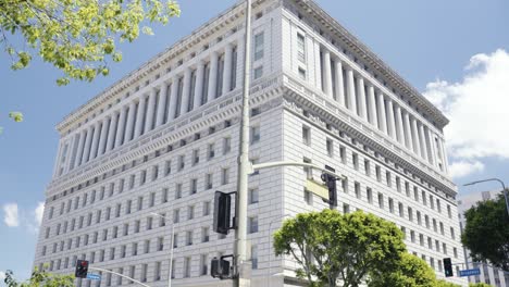 vista de la sala de justicia en los ángeles, california durante el verano con personas y coches cruzando las calles - movimiento natural de la cámara de pan orgánico