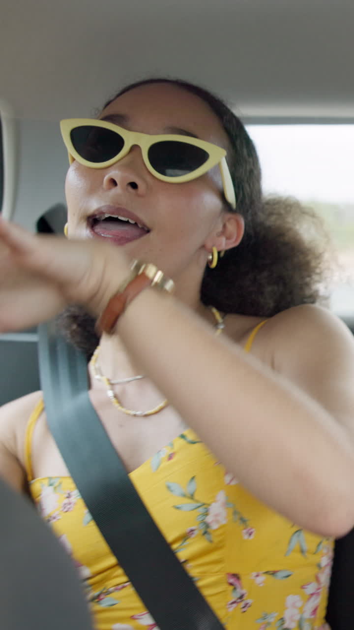 Young Woman in Sunglasses Talking and Singing in Car