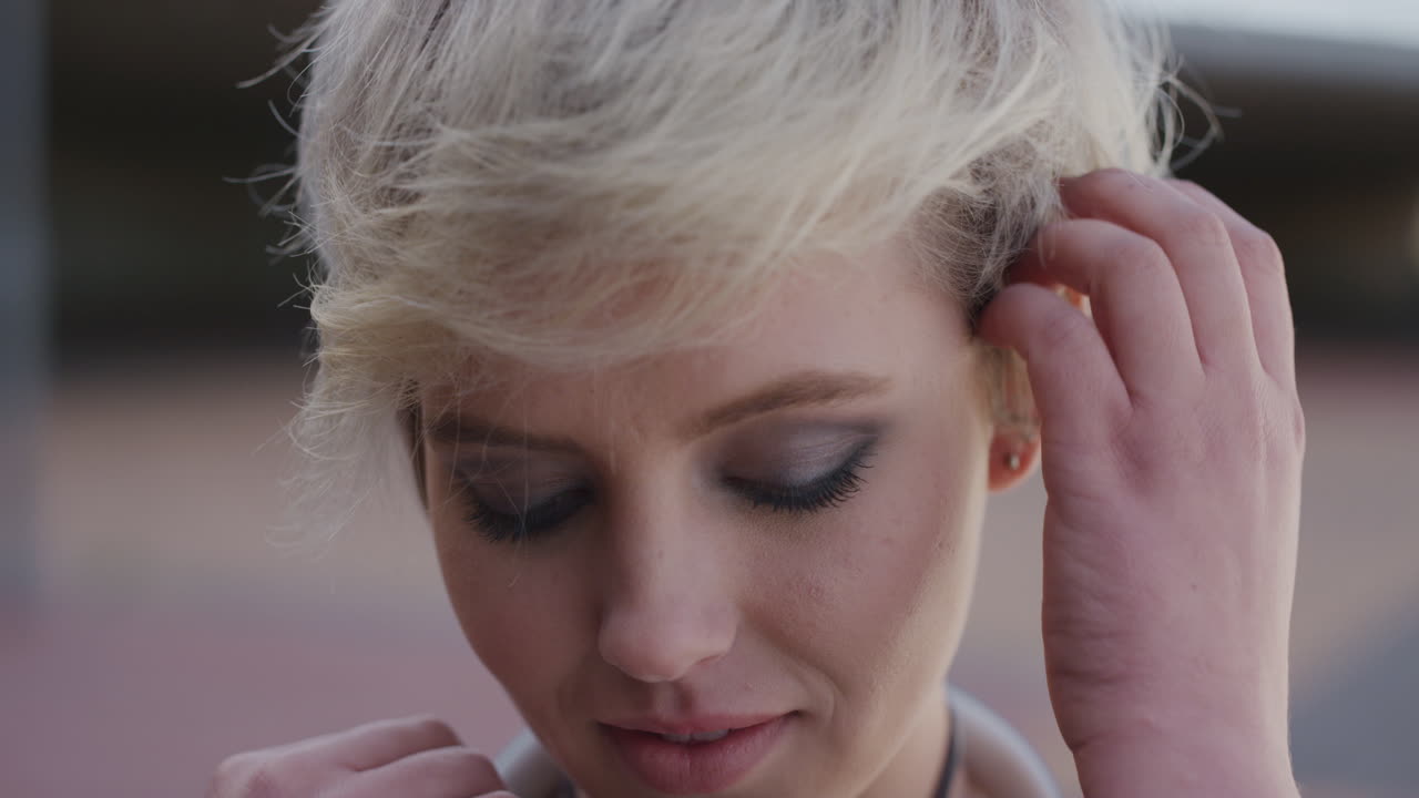 가까운 초상화 귀여운 젊은 여성 학생 미소 짓는 머리카락을 통해 달리는 손 부끄러운 백인 소녀 취약한 보이는 느린 동작