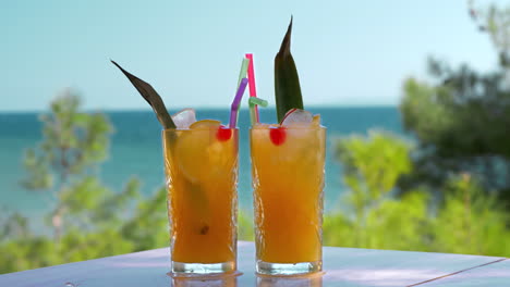 Refreshing-fruit-drinks-with-ice-cubes-falling-into-glasses