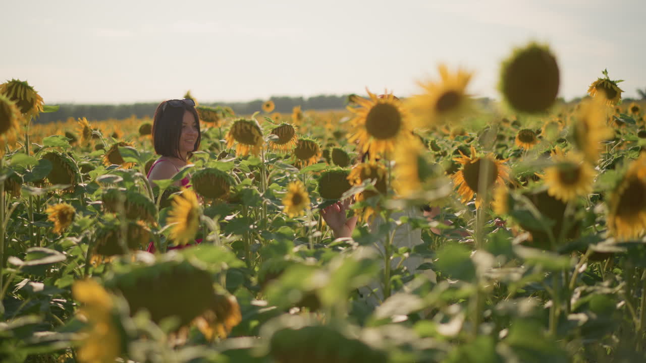 dos mujeres asiáticas riendo entre girasoles, videoblogueras de viajes grabando contenido espontáneo, vestidos vibrantes, rayos de sol, energía positiva, pétalos en primer plano, interacción divertida, escapada de verano