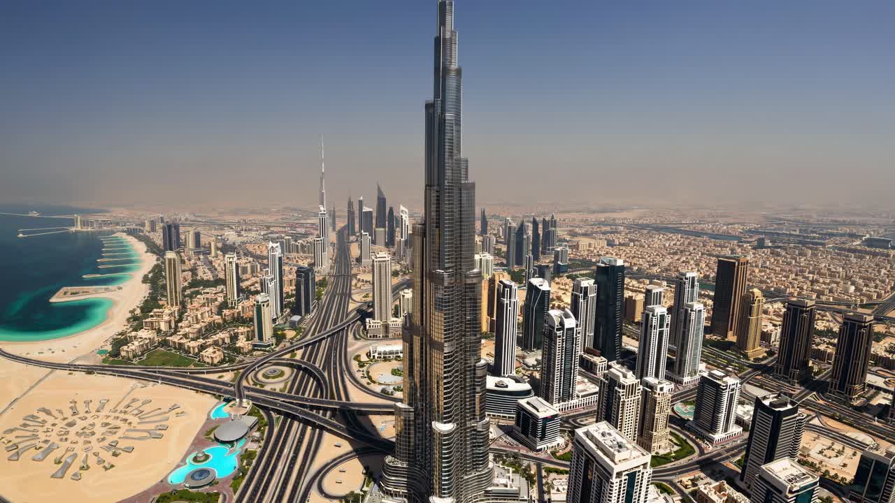 o imponente burj khalifa erguendo-se acima do horizonte urbano de dubai, revelando um intrincado projeto arquitetônico contra o ambiente costeiro circundante, capturando a majestosa escala vertical do marco