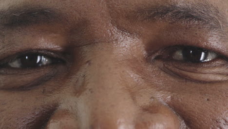 close up middle aged black man eyes looking happy at camera healthy eyesight