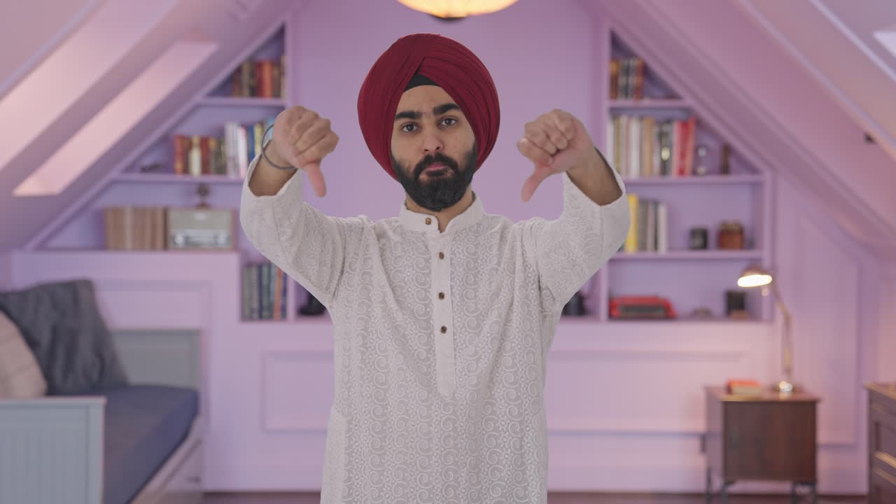 Uomo indiano Sikh deluso che mostra il pollice verso il basso