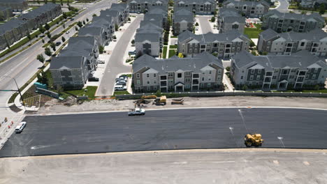 Real-estate-development-in-suburban-Utah-aerial-view-dolly-across-new-build-property-and-tarmac-road-construction