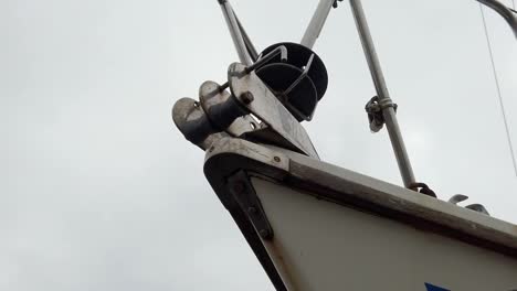 closeup on sailboat metal tackle hoist winch on front ship bow dolly right