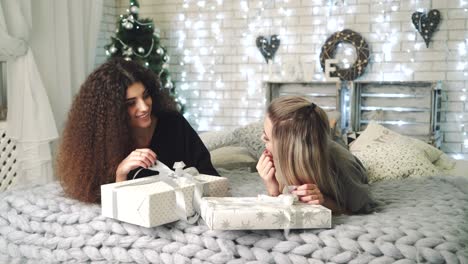 women holding christmas presents. young women with gift box in their hands in christmas decorated room