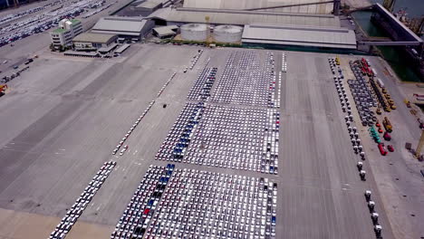 aerial view of logistics concept of commercial vehicles, cars and pickup trucks waiting to be load on to a roll-on-roll-off car carrier ship