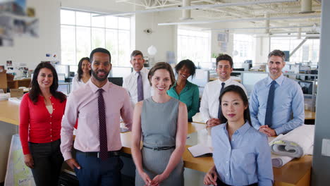 work colleagues looking to camera in office, elevated view