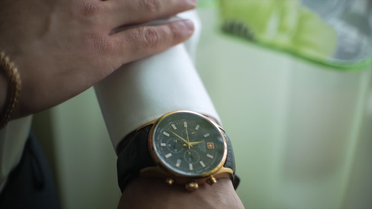 hombre ajustando reloj de pulsera de oro