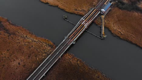 Aerial---Railroad-bridge-over-river-in-Somerleyton,-England,-wide-shot-above