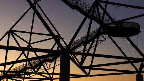 Silhouette-of-people-climbing-stairs-of-Tetraeder-Bottrop,-dusk-time-lapse